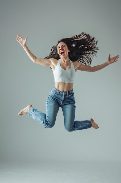 a woman in a white tank top is jumping in the air with her arms outstretched