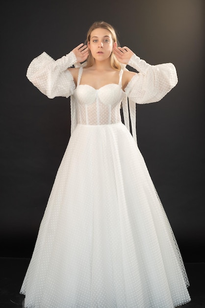 A woman in a white wedding dress with a long sleeved top and a long sleeved top.