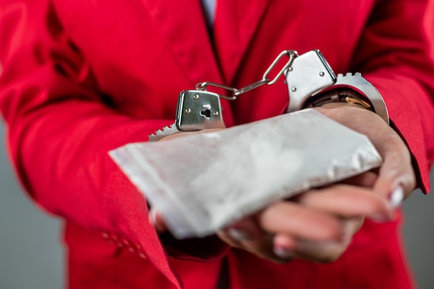 Woman whose hands are handcuffed with money and drugs