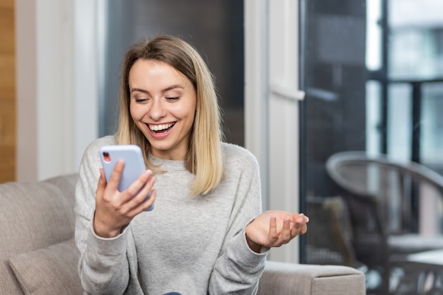  woman winner screaming yes rejoicing success looking at cellphone