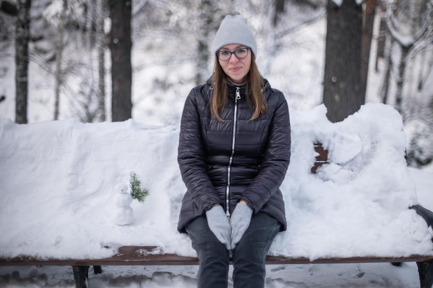 Woman in winter jacket walking in snowy winter forest snowy winter day