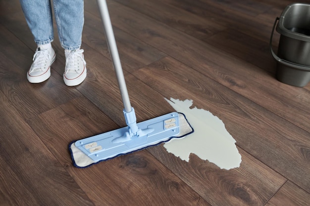 Woman wiping the dirty floor with mop