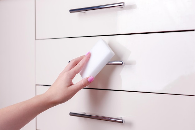 Woman wiping the kitchen with a sponge