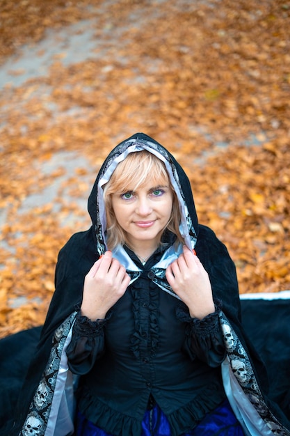 A woman in a witch suit in a dense forest on a ritual