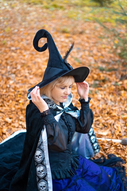 A woman in a witch suit in a dense forest on a ritual