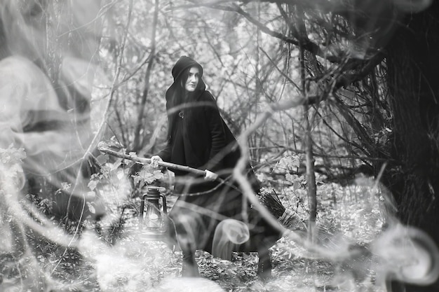 A woman in a witch suit in a dense forest on a ritual