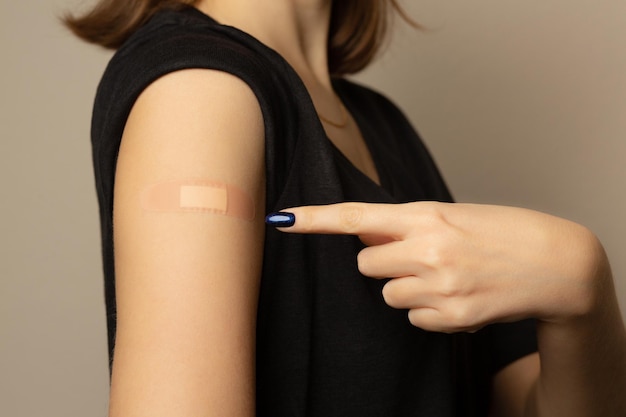 Woman with adhesive plaster on her hand after vaccination