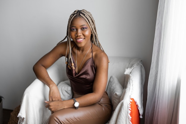 woman with afro braids sitting in armchair at home