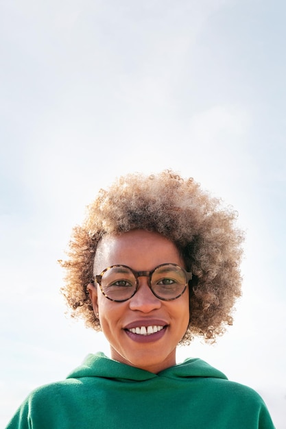 Woman with afro hair smiling looking at camera