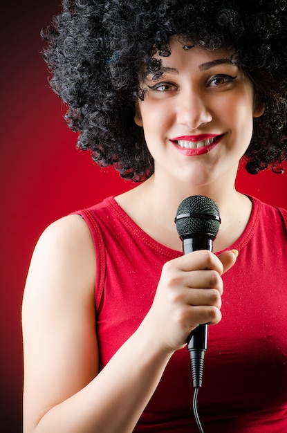 Woman with afro hairstyle singing in karaoke