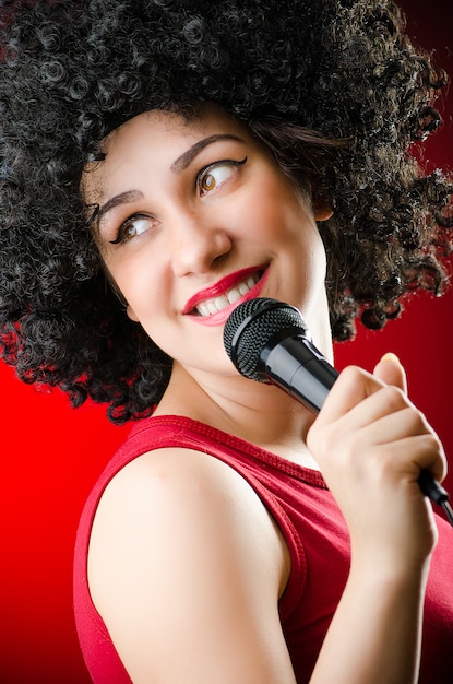 Woman with afro hairstyle singing in karaoke