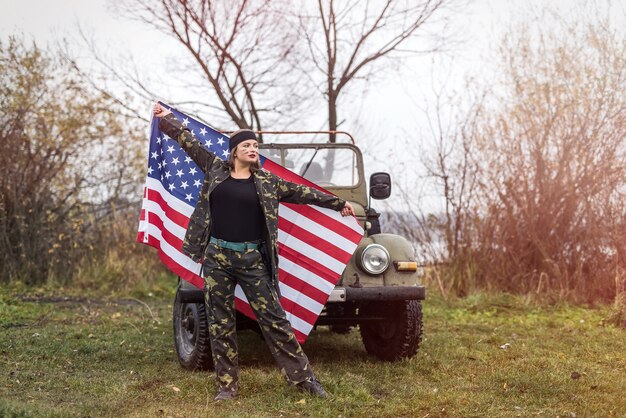 Photo woman with american flag and military car