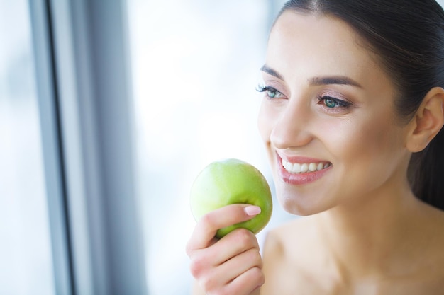 Woman With Apple. Beautiful Girl With White Smile, Healthy Teeth. High Resolution Image