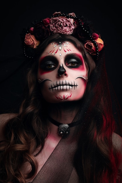 woman with artistic spooky makeup and fresh flowers on head standing prepared for Halloween party