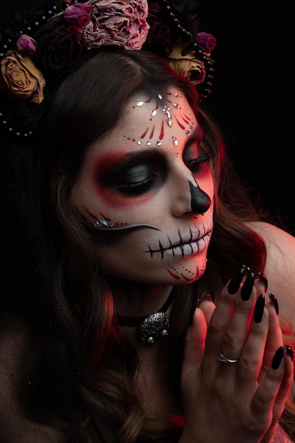 Woman with artistic spooky makeup and fresh flowers on head standing prepared for halloween party