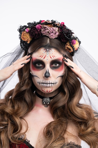 Woman with artistic spooky makeup and fresh flowers on head standing prepared for halloween