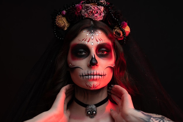 Woman with artistic spooky makeup and fresh flowers on head standing prepared for halloween