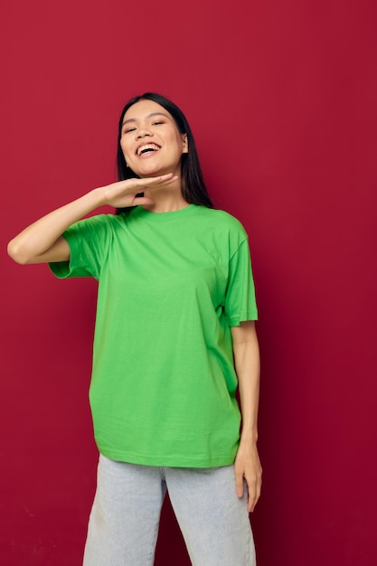 Woman with Asian appearance green tshirt gestures with his hands isolated background unaltered