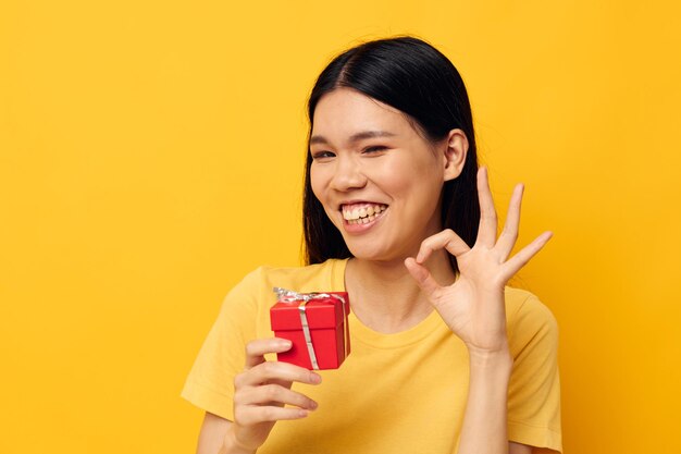 Woman with asian appearance little red gift box fun isolated background unaltered