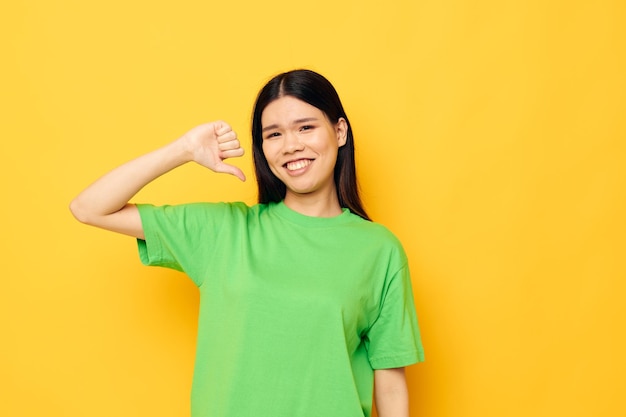 Woman with Asian appearance posing in green tshirt emotions copyspace isolated background unaltered