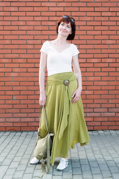 Woman with a backpack on a background of a brick wall