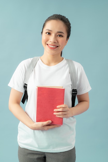 Woman with a bag and red books on her hands over blue background