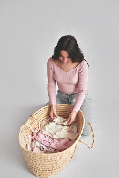 Woman with basket full of children's clothes Young mother Laundry and cleaning