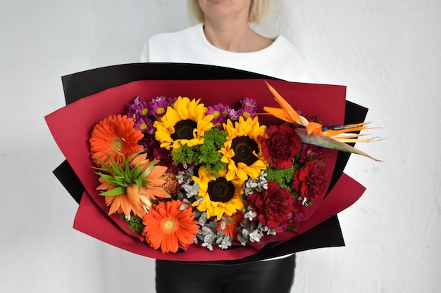 Woman with beautiful flowers in hands indoors background bouquet of flowers for flower shop