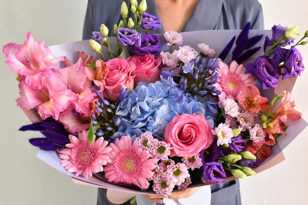 Woman with beautiful flowers in hands indoors background bouquet of flowers for flower shop