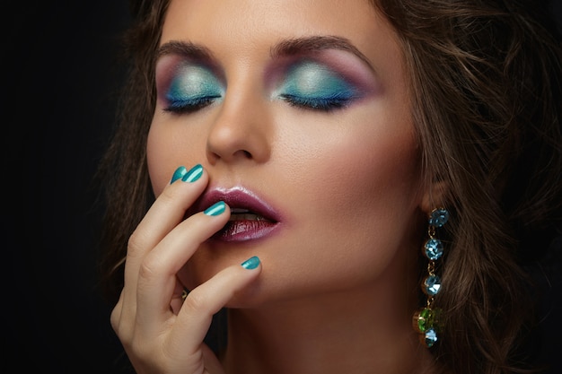 Woman with a beautiful makeup and hairstyle wearing shiny earrings