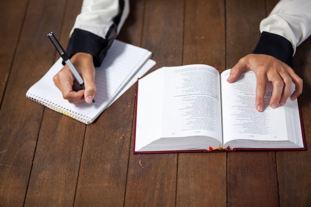 Woman with a bible writing on notepad