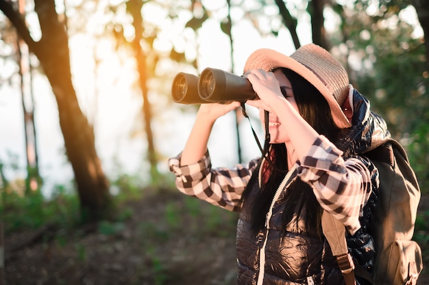 Woman with Binoculars and Telescope in Rain Forest