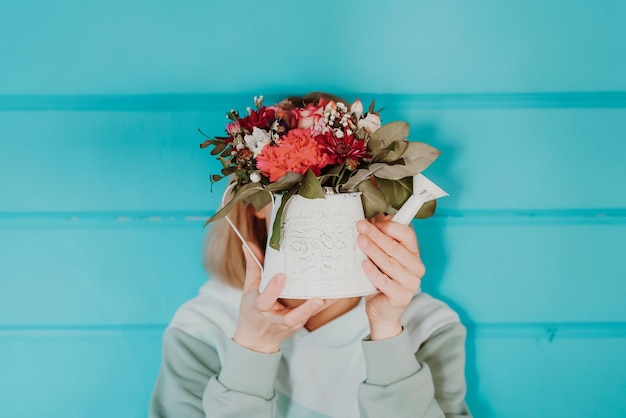 Woman with a bouquet of flowers on a blue background