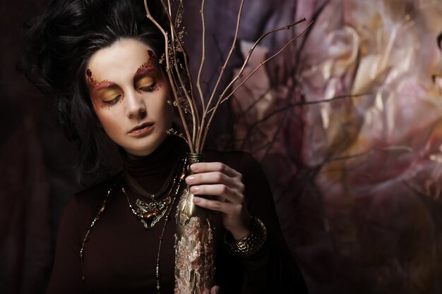 Photo woman with bright make up with dry branches