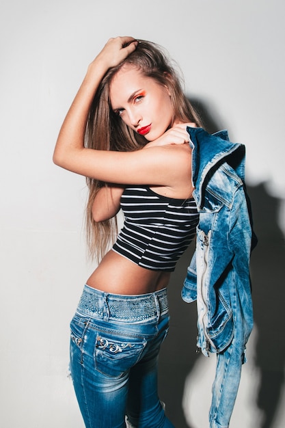 Woman with bright makeup jeans clothes posing on camera