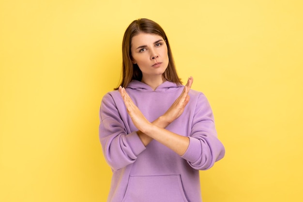 Woman with brown hair showing x sign with hands there is no way more hopelessness