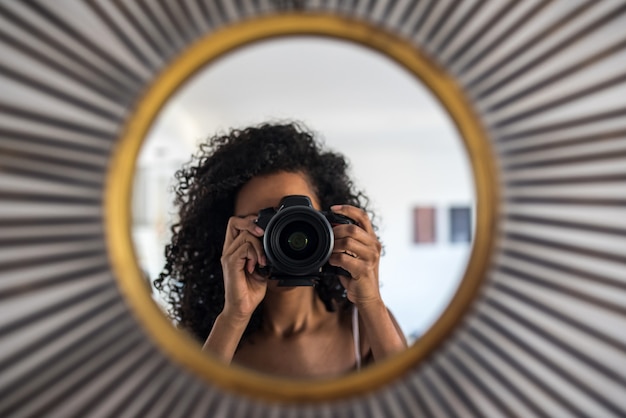 Woman with camera taking picture of reflection