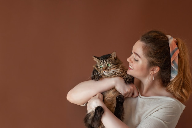 Woman with cat. Pet.Fluffy gray cat in the arms of the owner