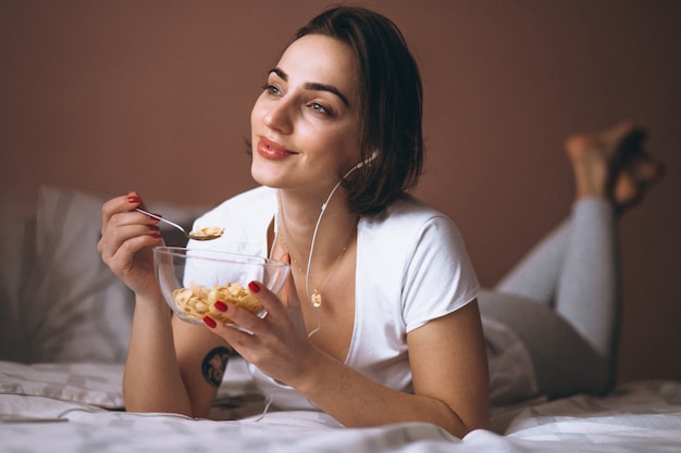 Woman with cereals and earphones