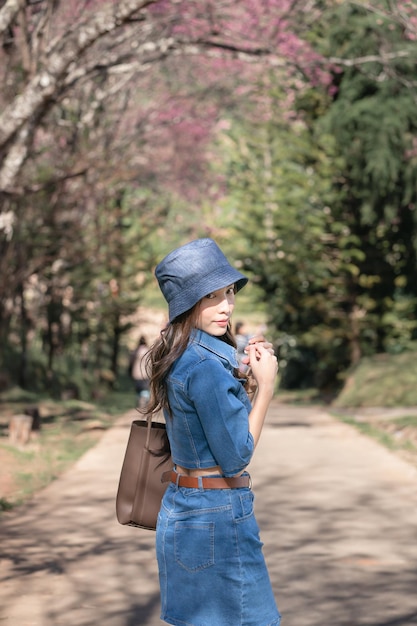 Woman with cherry blossoms or sakura flower blooming in the park