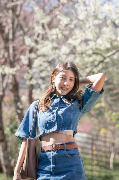 Woman with cherry blossoms or sakura flower blooming in the park