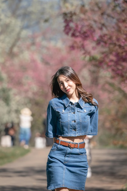 Woman with cherry blossoms or sakura flower blooming in the park