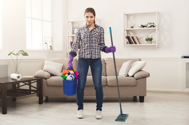 Woman with cleaning equipment ready to clean room