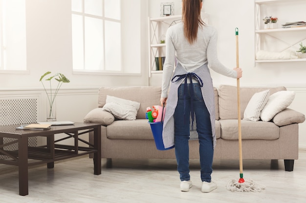 Woman with cleaning equipment ready to clean room