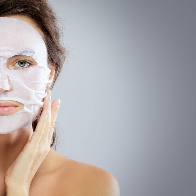 Woman with a cloth moisturizing mask on her face