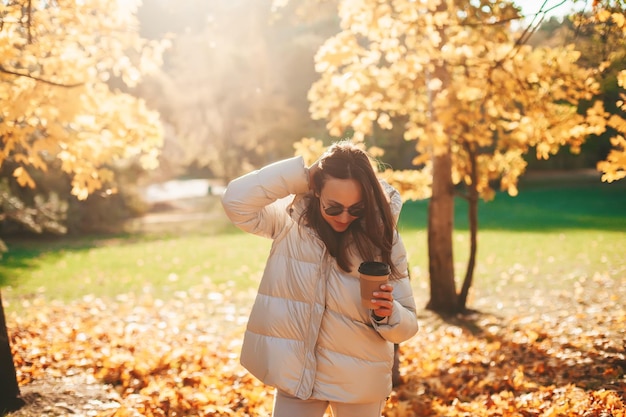 Woman with coffee cup in the autumn park