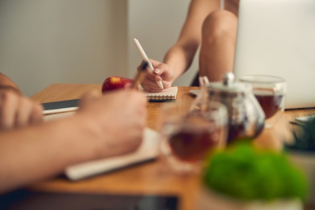 Woman with coloured nails writing with pen