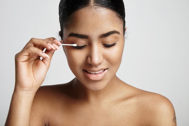 Woman with a cotton swab stick clean her eyelid