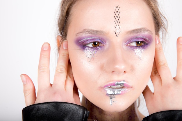 Woman with creative make up and flowers in mouth