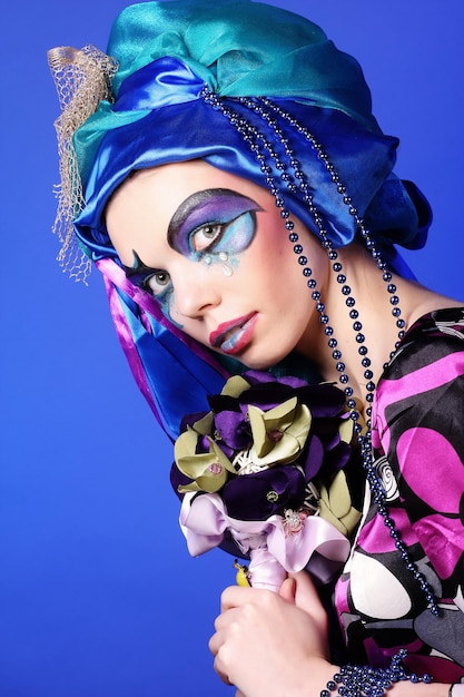 Woman with creative make up holding a bouquet of jewelry